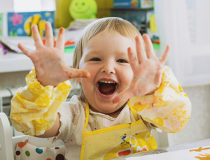 Ein Kind zeigt fröhlich seine Hände